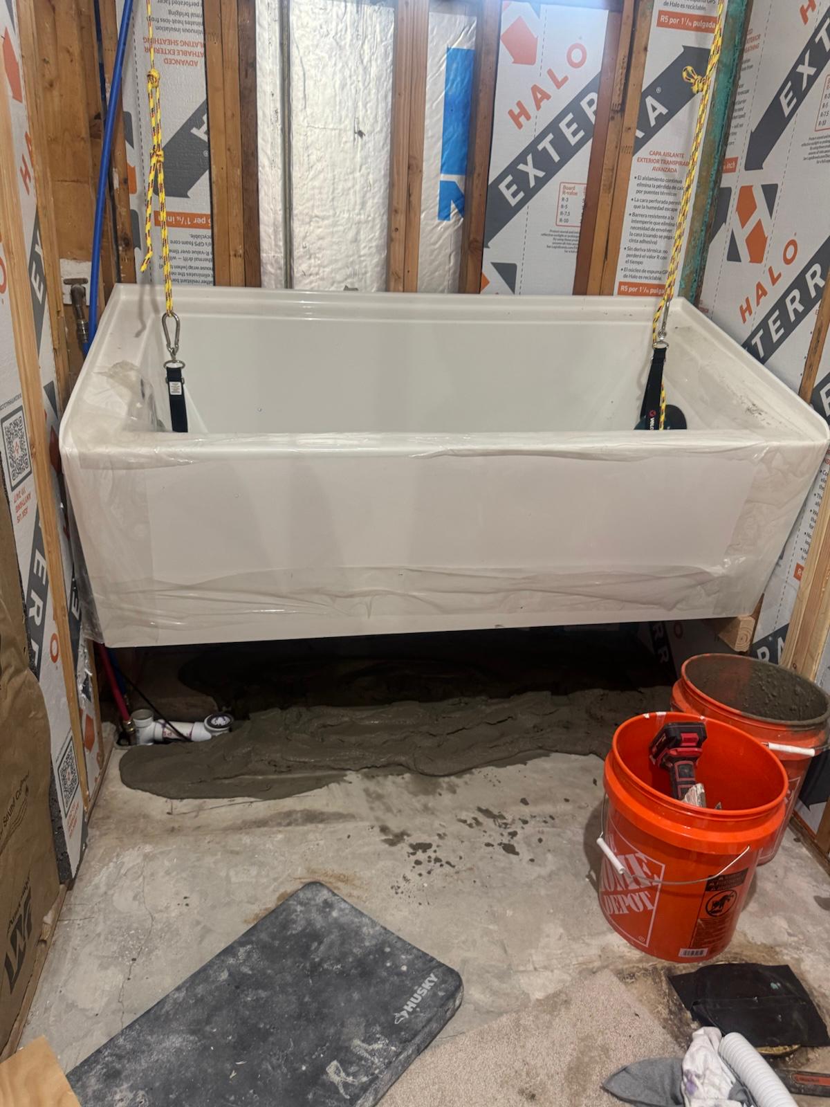 Same bathroom during construction, bare studs with the tub set in place